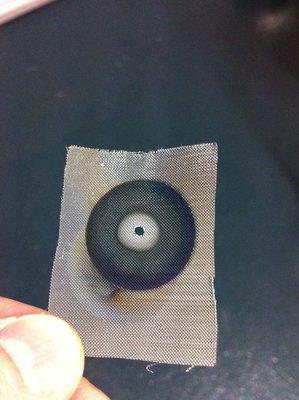 Old stainless steel cathode mesh showing spot where beam focus has burned a 1 mm diameter hole through the mesh.