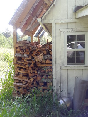 New shed on main building I live in.  Solar panels make a nice roof - note the one piiece of roofing tin I needed to fill in the gap there - a couple cords maybe.  All sound red oak.