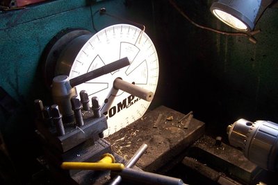 Lathe setup to change "billet" into a grid.  First hole bored to length.